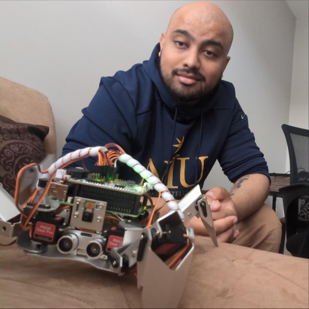 Alex Veerasammy with Qisa, a robot.